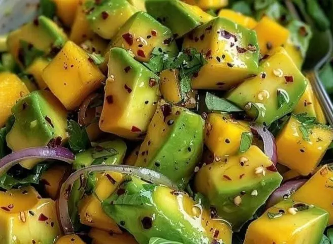 Salat aus Avocado- und Mangowürfeln mit roten Zwiebeln und Chili