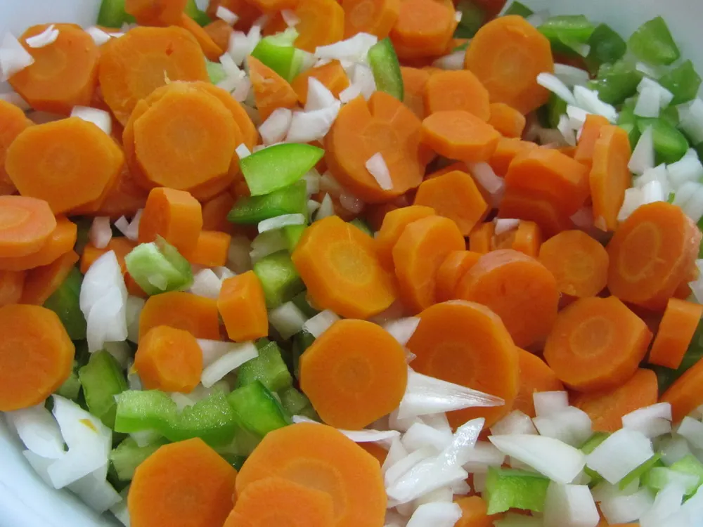Karottenscheiben mit Paprika und Zwiebel, bevor die heiße Sauce darüberkommt