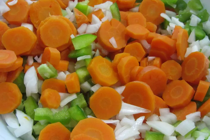 Karottenscheiben mit Paprika und Zwiebel, bevor die heiße Sauce darüberkommt