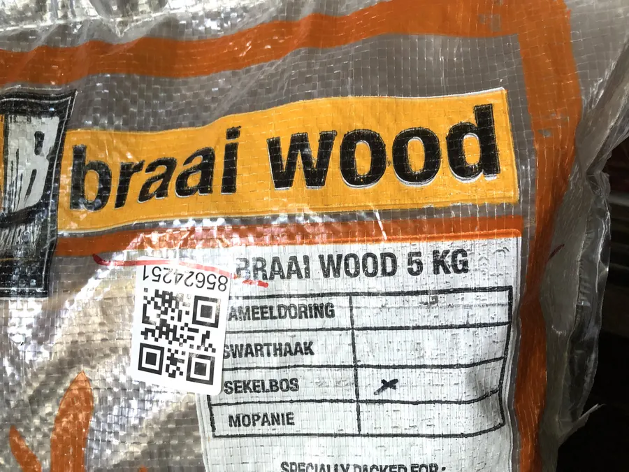 Abgepackter Sack Braaiholz im Handel, mit Angabe der Holzarten