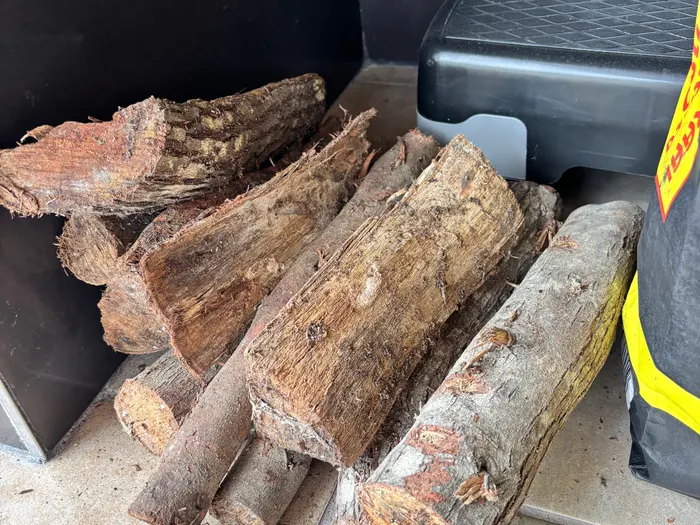 Gespaltene Scheite im Holzlager, Rinde und Schnittflächen erkennbar