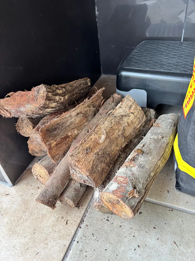 Gespaltene Scheite im Holzlager, Rinde und Schnittflächen erkennbar