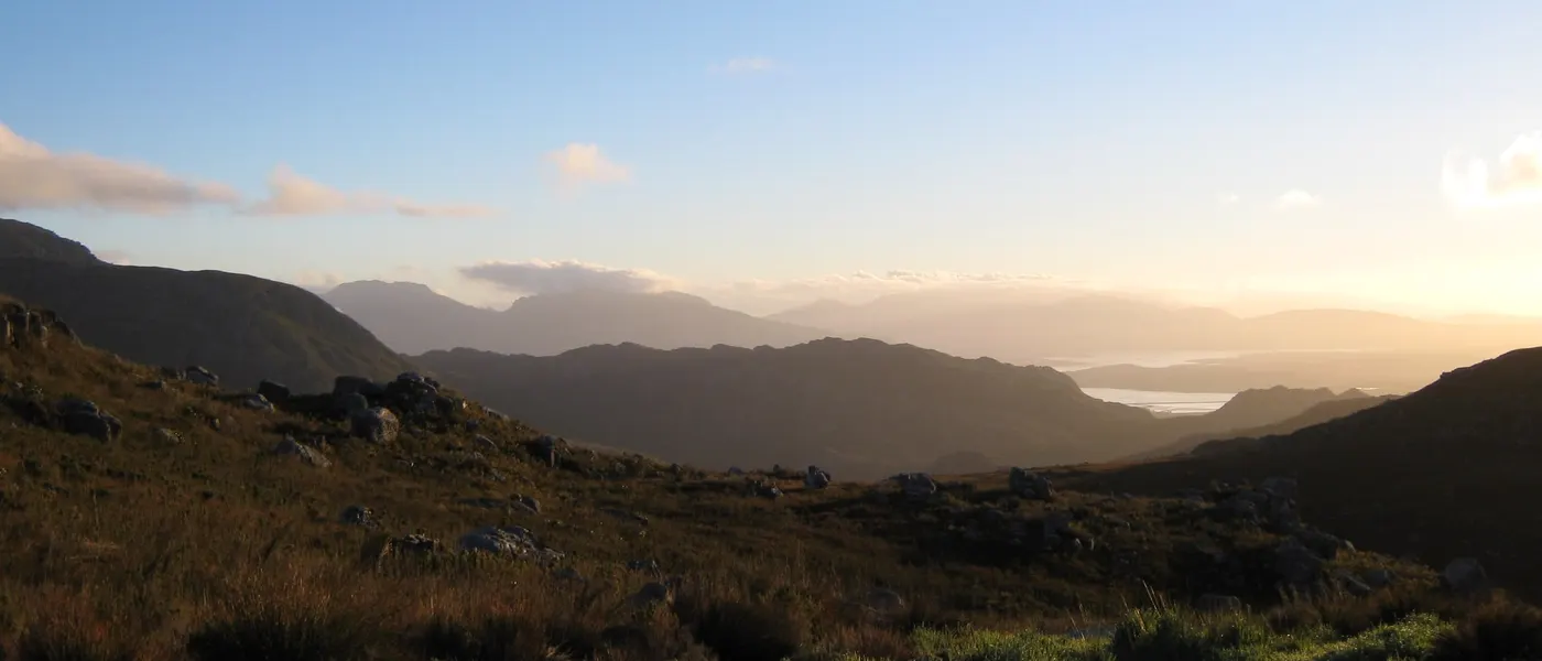 Fynbos-Hänge und die Kämme der Hottentots-Holland-Berge im Abendlicht, rechts das Wasser des Theewaterskloof-Staudamms