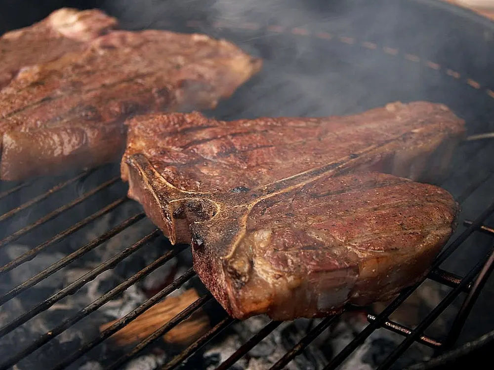 T-Bone-Steaks auf dem Rost über offener Glut