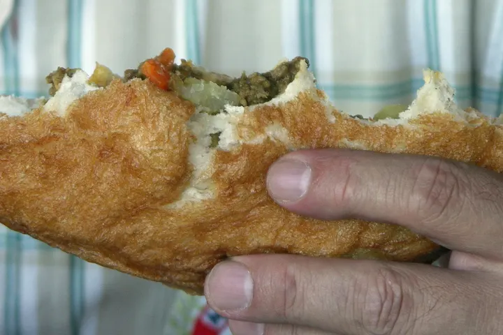 Aufgeschnittener Vetkoek, gefüllt mit Curry-Hack